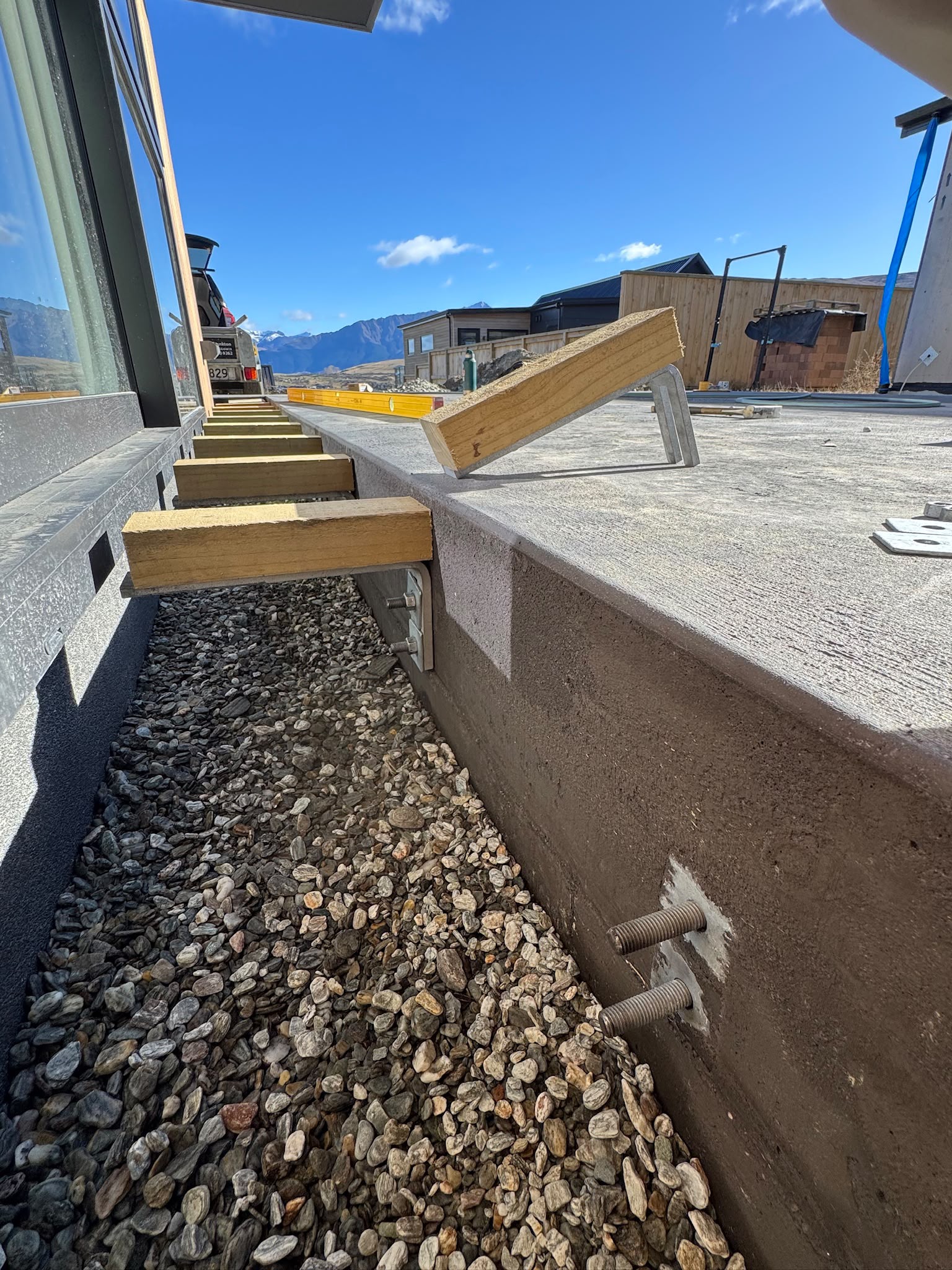 Even Entry bracket system installed along a concrete slab edge with alpine backdrop