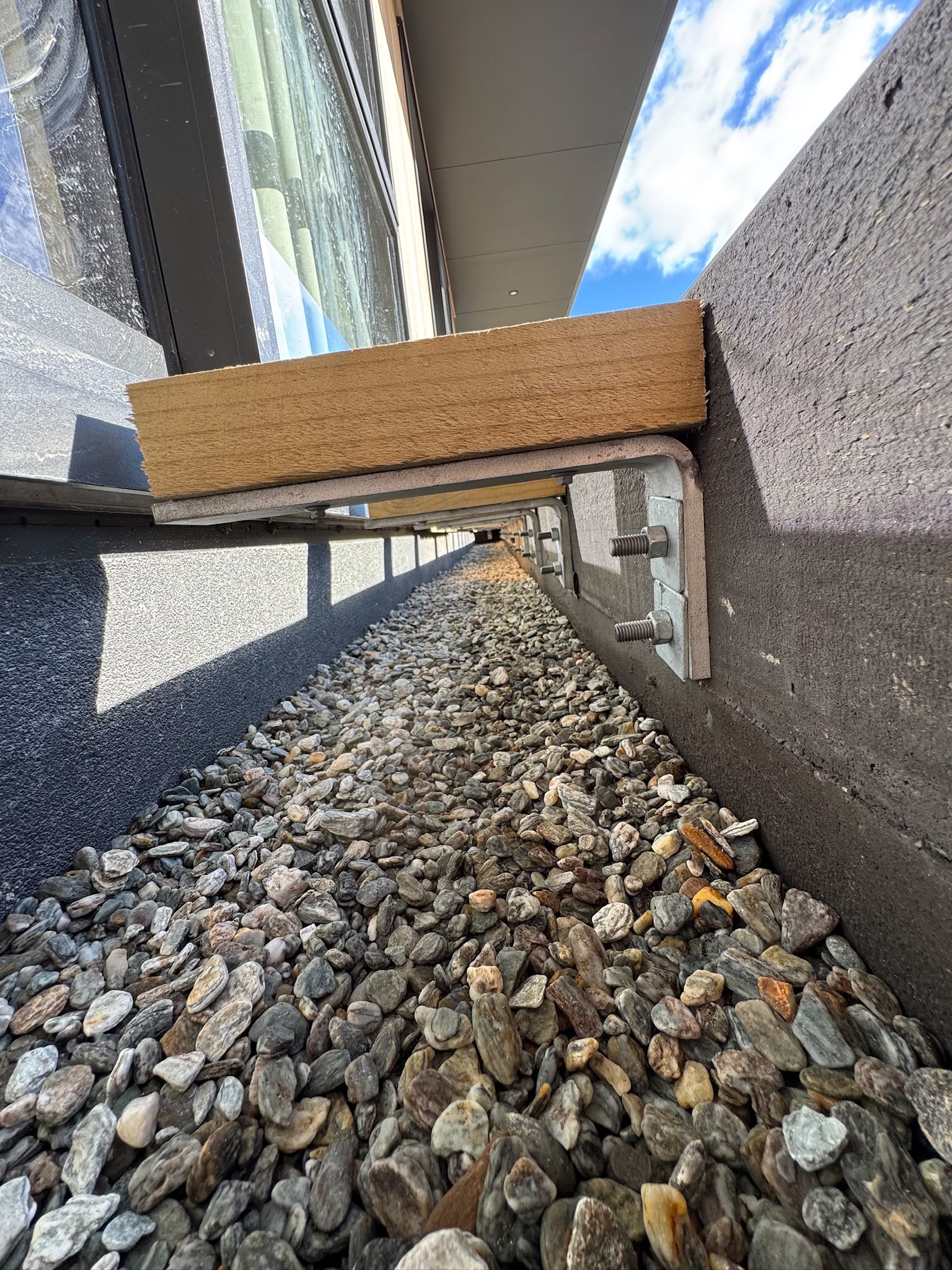 Close-up of Even Entry bracket system bolted to concrete slab edge